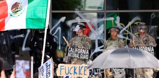 Manifestantes se reúnen mientras miembros de la Guardia Nacional de California se encuentran frente al Edificio Federal Edward R. Roybal, tras su despliegue por el presidente estadounidense Donald Trump, en respuesta a las protestas contra las redadas migratorias, en Los Ángeles, California, EE. UU., el 9 de junio de 2025 | FOTO: REUTERS/DAVID SWANSON