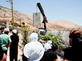 Drusos observan cómo el Ejército israelí coloca un muro de hormigón en la línea de alto el fuego entre los Altos del Golán ocupados por Israel y Siria, en medio del conflicto en curso en las zonas drusas de Siria, en Majdal Shams, el 17 de julio de 2025 - REUTERS/ AMMAR AWAD