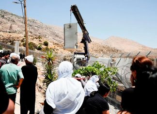 Drusos observan cómo el Ejército israelí coloca un muro de hormigón en la línea de alto el fuego entre los Altos del Golán ocupados por Israel y Siria, en medio del conflicto en curso en las zonas drusas de Siria, en Majdal Shams, el 17 de julio de 2025 - REUTERS/ AMMAR AWAD